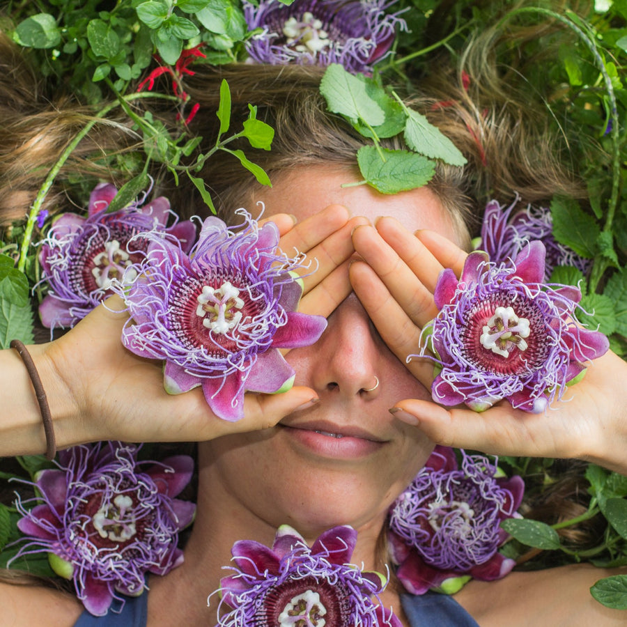 Passionflowers held over closed eyes